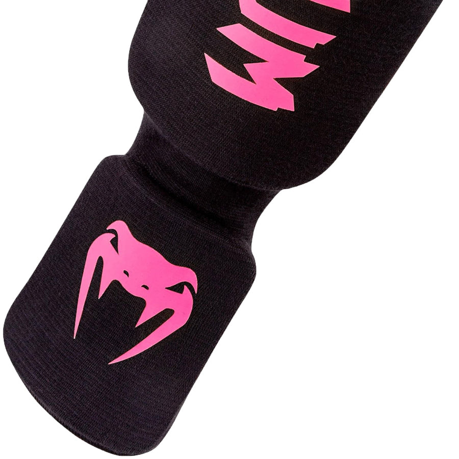 Venum Kontact -sukkamalliset slip-on säärisuojat. Kuvassa jalkateräosa, jossa pinkki venum-logo. pt.combat.fi