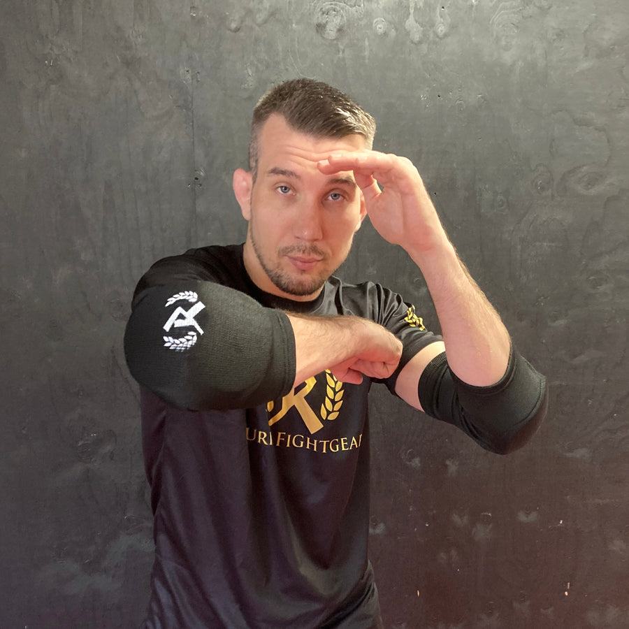Rurik FG kyynärpääsuojat on suunniteltu erityisesti kamppailulajien harrastajille, jotka vaativat sekä mukavuutta että maksimaalista suojaa. Ne soveltuvat erinomaisesti Muay Thaihin, MMA:han ja muihin täyskontaktin lajeihin, joissa kyynärpäihin kohdistuu iskuja ja kontaktia. Kuvassa kyynärsuojat Henrin päällä. 