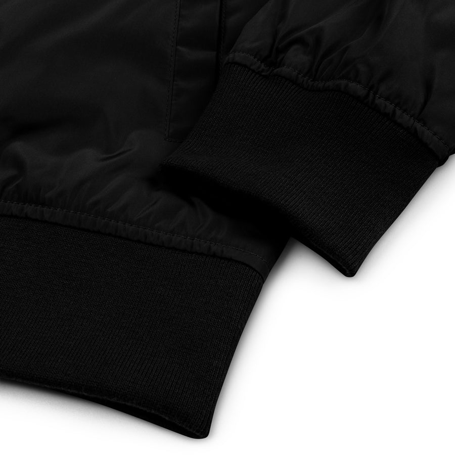 Rurik Fightgear-lentäjänpusakka.
Rurik FG "R" -logo rintapielessä sekä riimulogo selässä monivärisesti brodeerattuna. Kuvassa pilottitakin resorit. PT-Combat.Fi