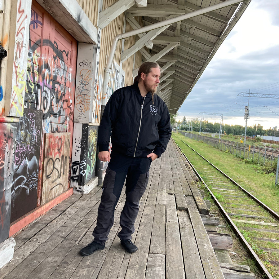 Rurik Fightgear-lentäjänpusakka.
Rurik FG "R" -logo rintapielessä sekä riimulogo selässä monivärisesti brodeerattuna. Kuvassa pilottitakki  Mikan päällä. PT-Combat.Fi